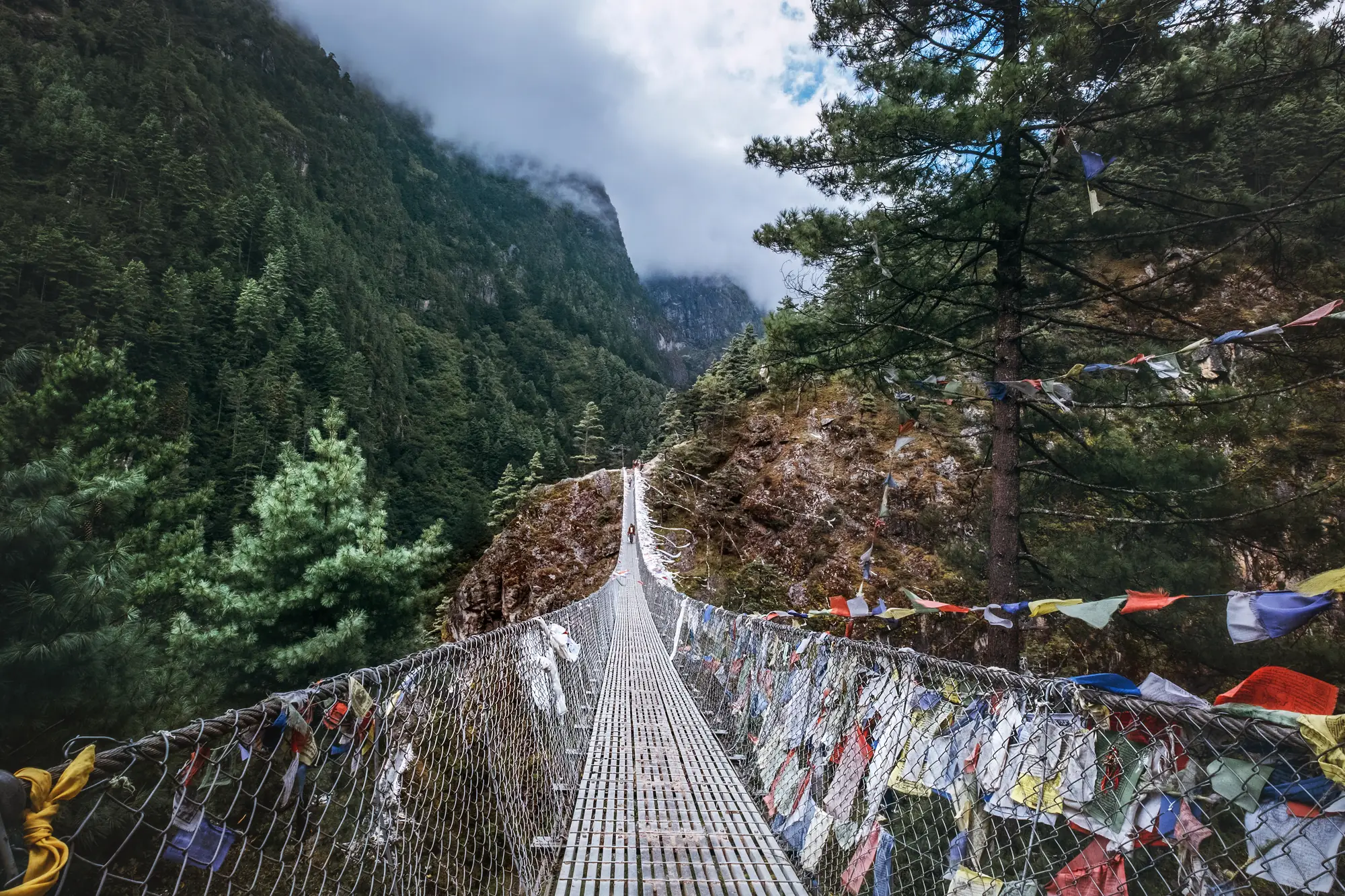 Himalayan trail with prayer flags and suspension bridge